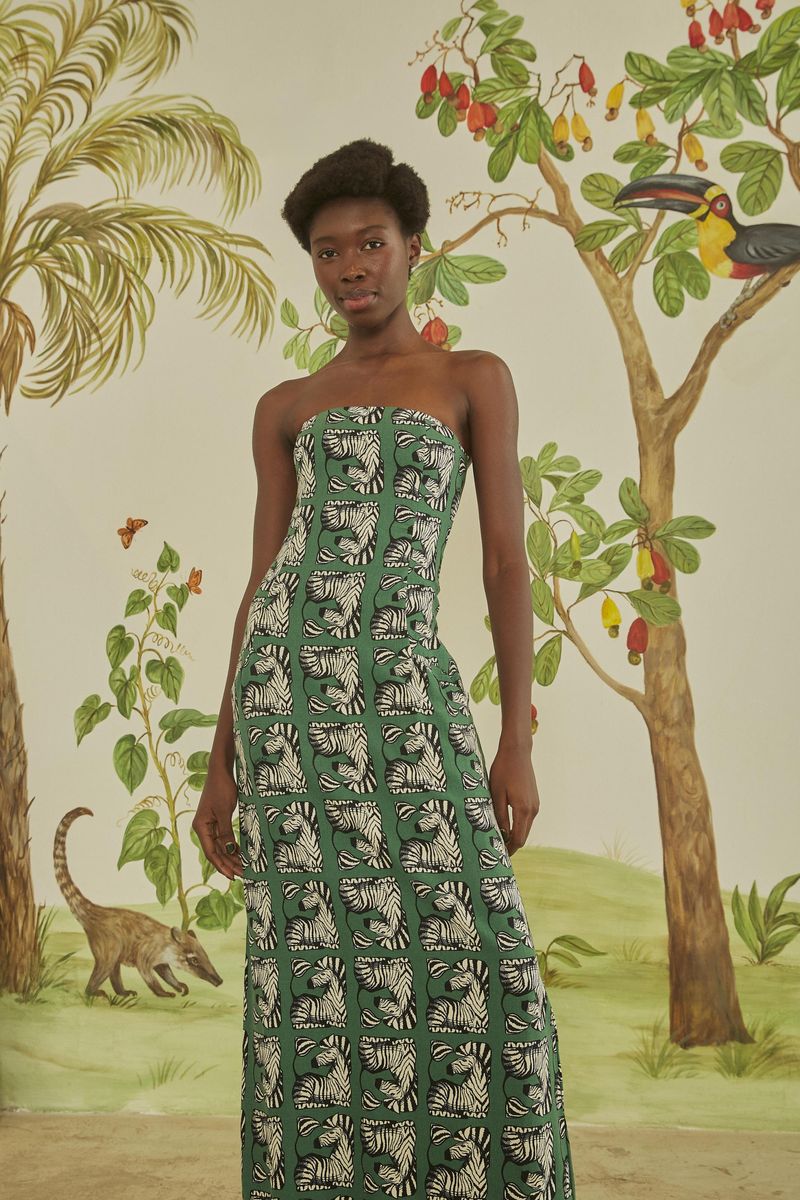 Vestido-largo-sin-tirantes-con-estampado-de-cebras-sobre-fondo-verde-exhibido-en-un-escenario-tropical.