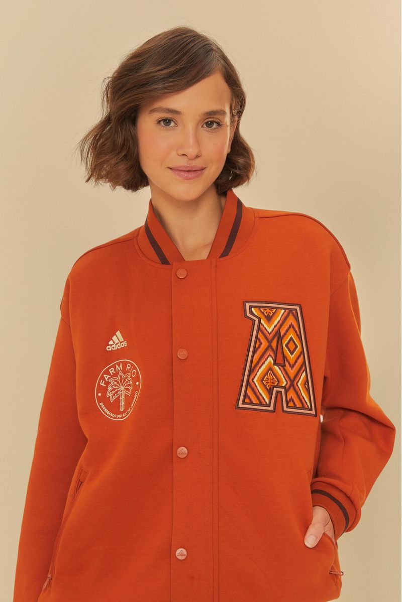 Modelo-vistiendo-chaqueta-Adidas-marron-con-parches-decorativos-vista-frontal.