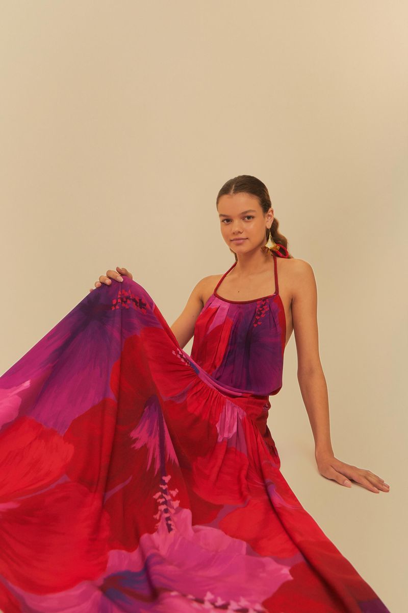 Vestido cropped estampado con tirantes finos ajustables, exhibido en pose sentada destacando su falda fluida.