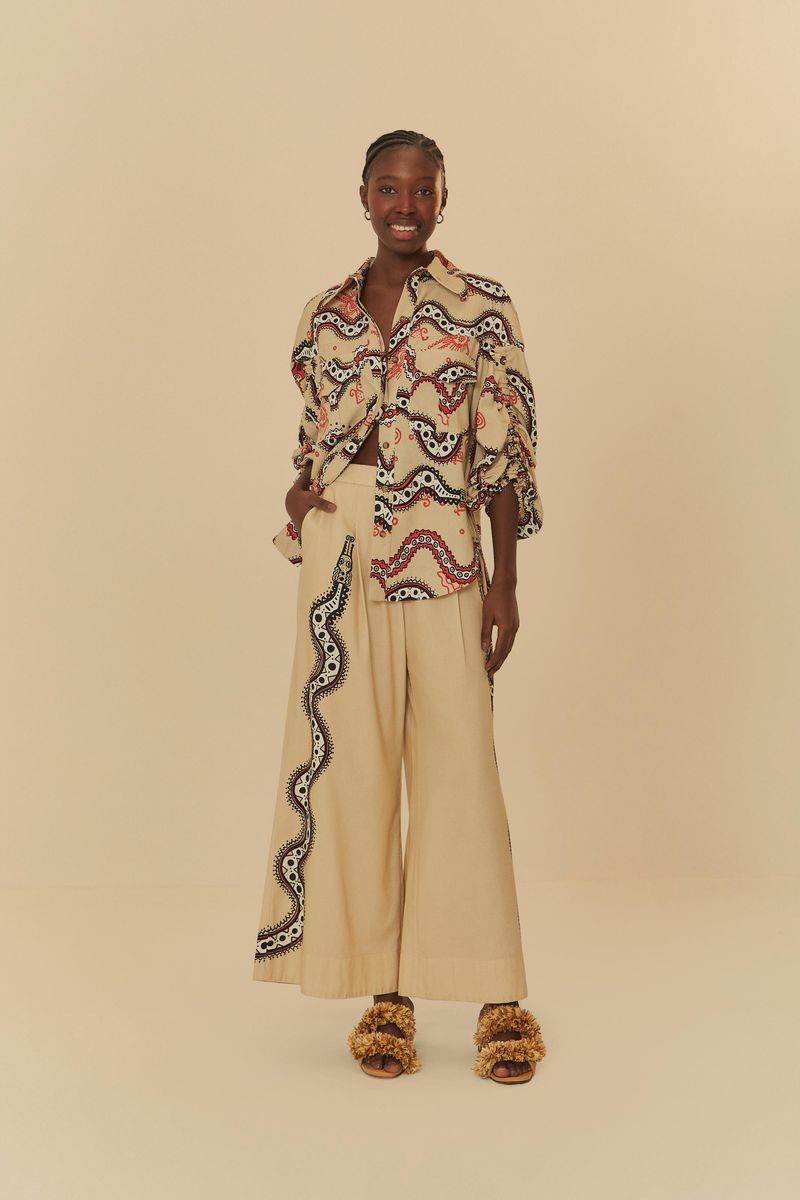 Modelo vistiendo pantalón pantalona con estampado gráfico de serpiente y camisa combinada.