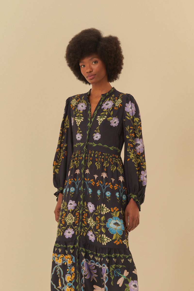 Vestido estampado con diseño floral en fondo oscuro, con mangas largas y largo midi.