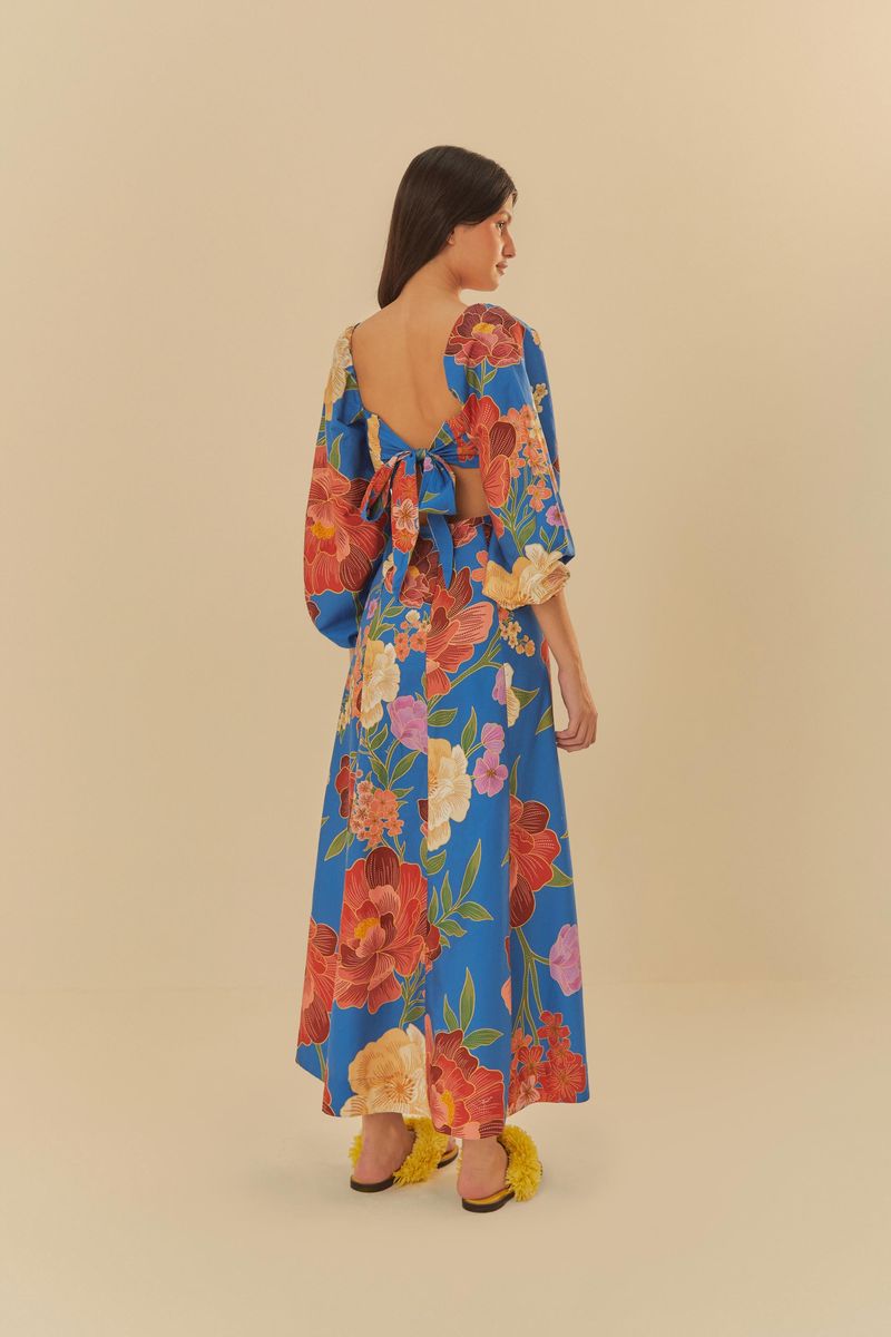 Vista trasera del vestido azul con estampado floral, mostrando el lazo por detrás y su largo.