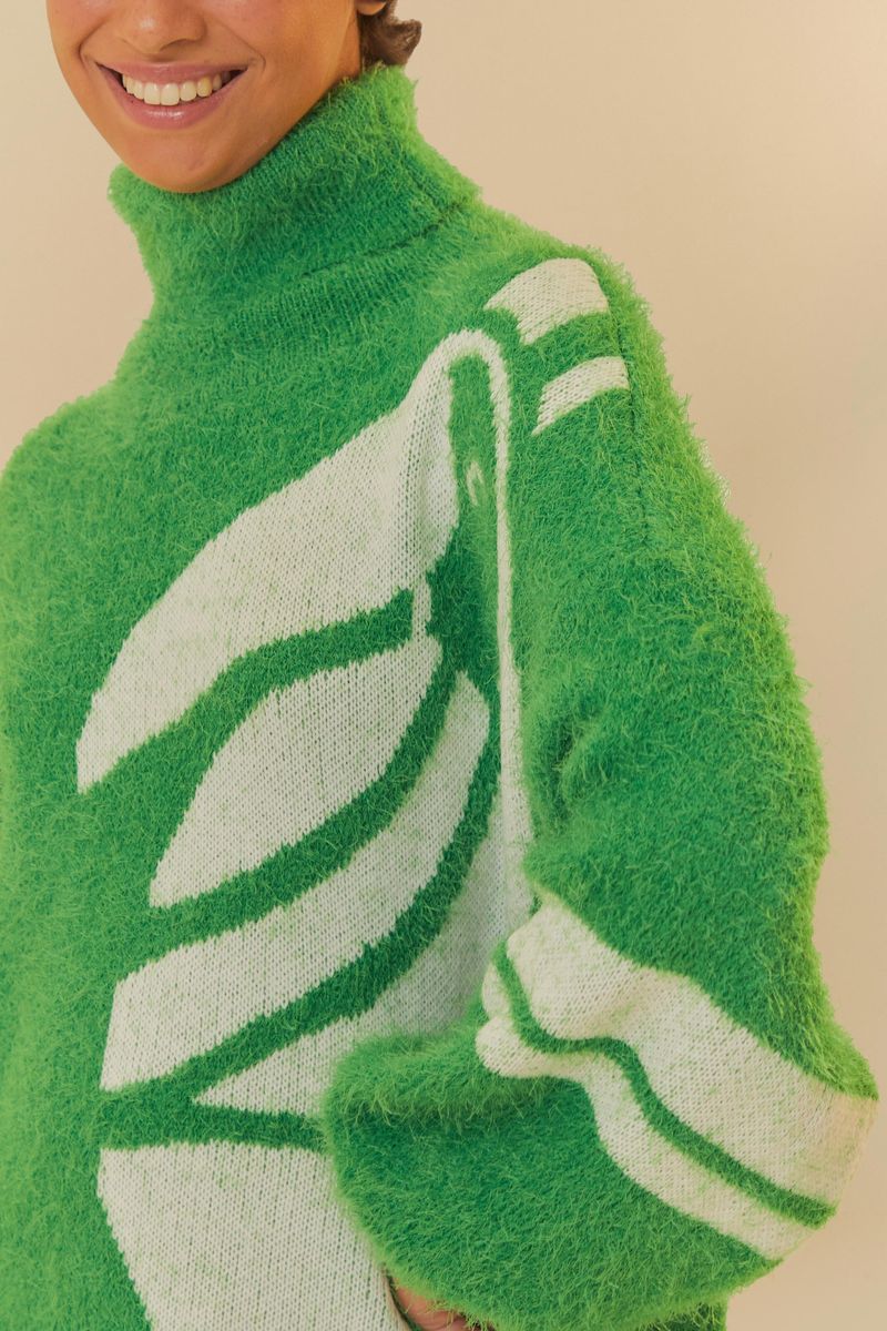 Detalle del tejido verde con patrón geométrico en blanco del cardigan.