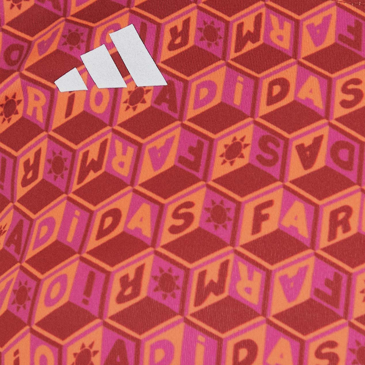 Detalle del estampado geométrico del top Adidas Logomania purpura con elementos tipográficos.