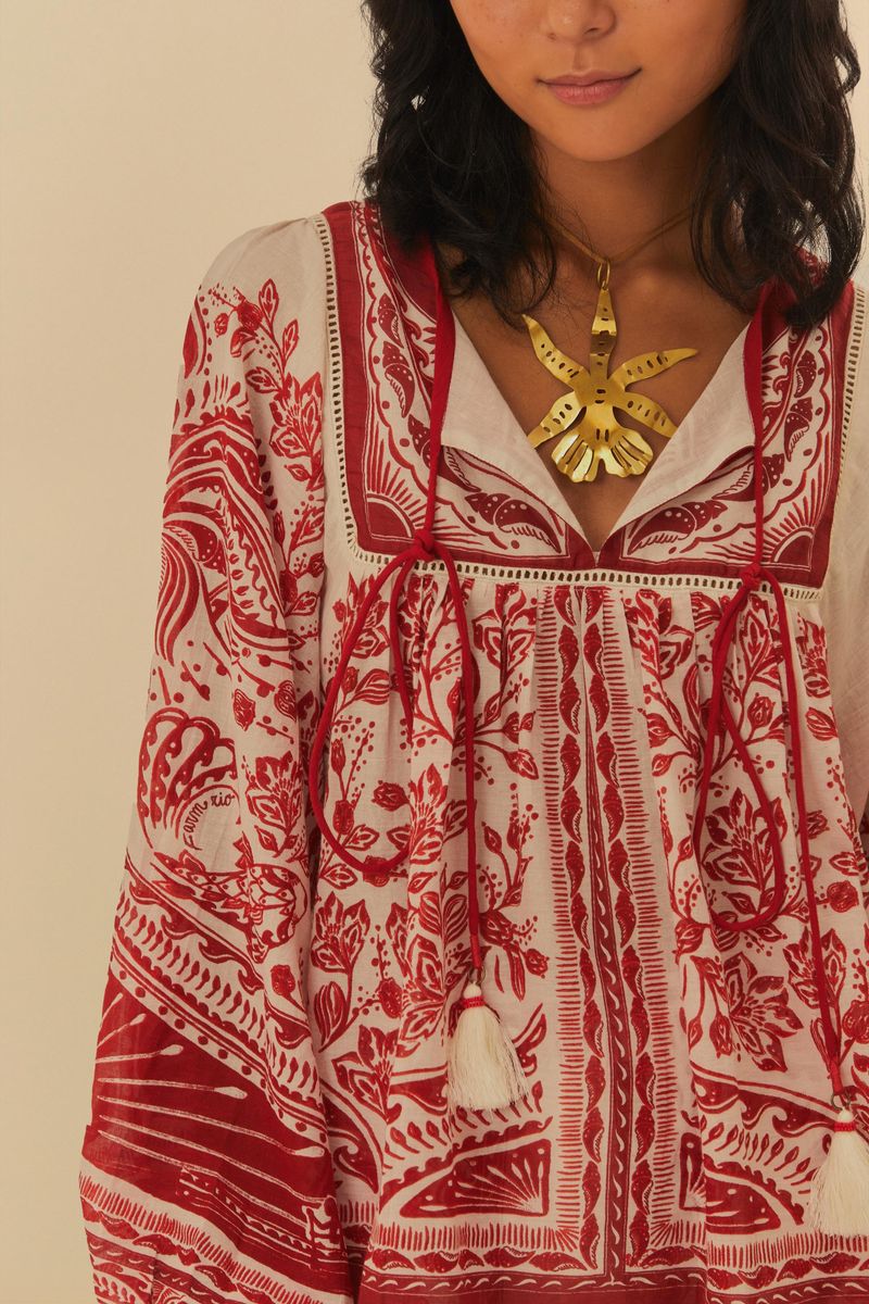 Detalle del escote en V de la blusa estampada con detalles florales.