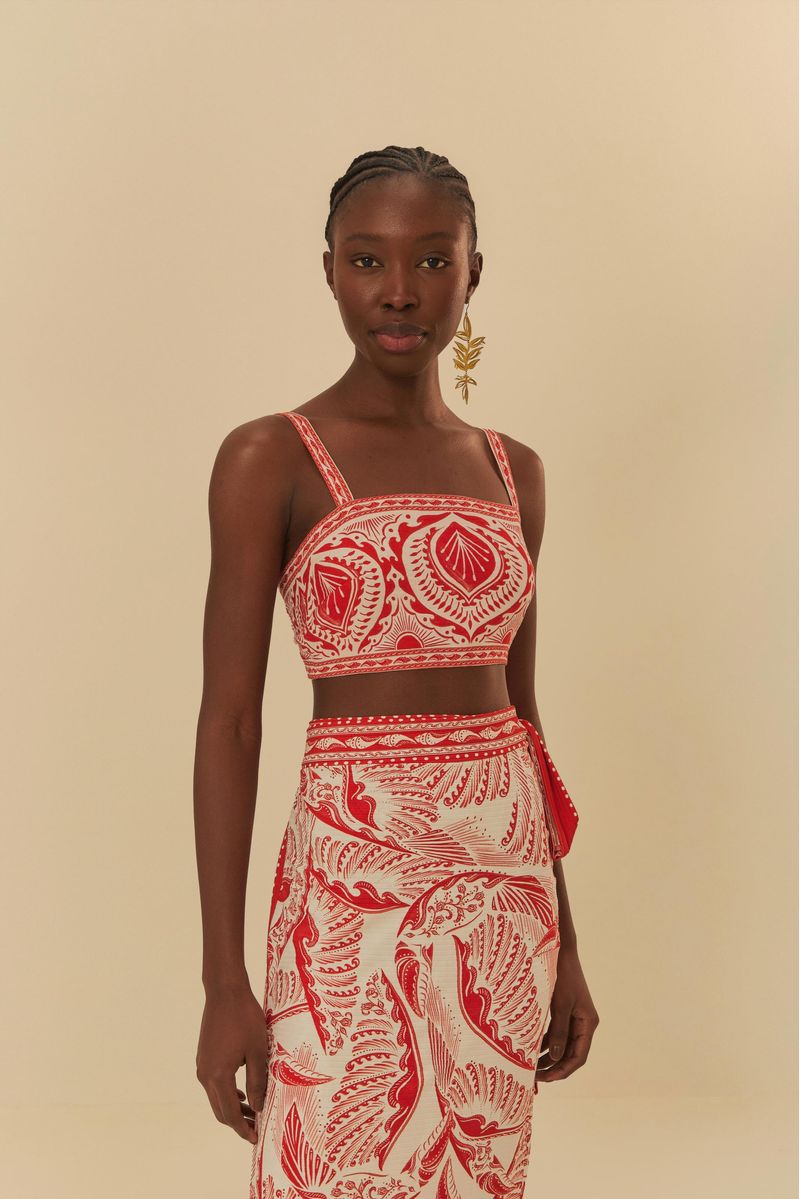 Detalle del top estampado con diseño botánico en rojo y blanco.