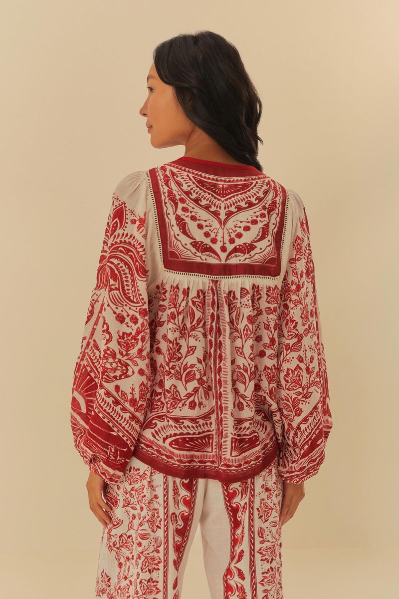 Vista trasera de la blusa estampada con detalles florales en rojo.