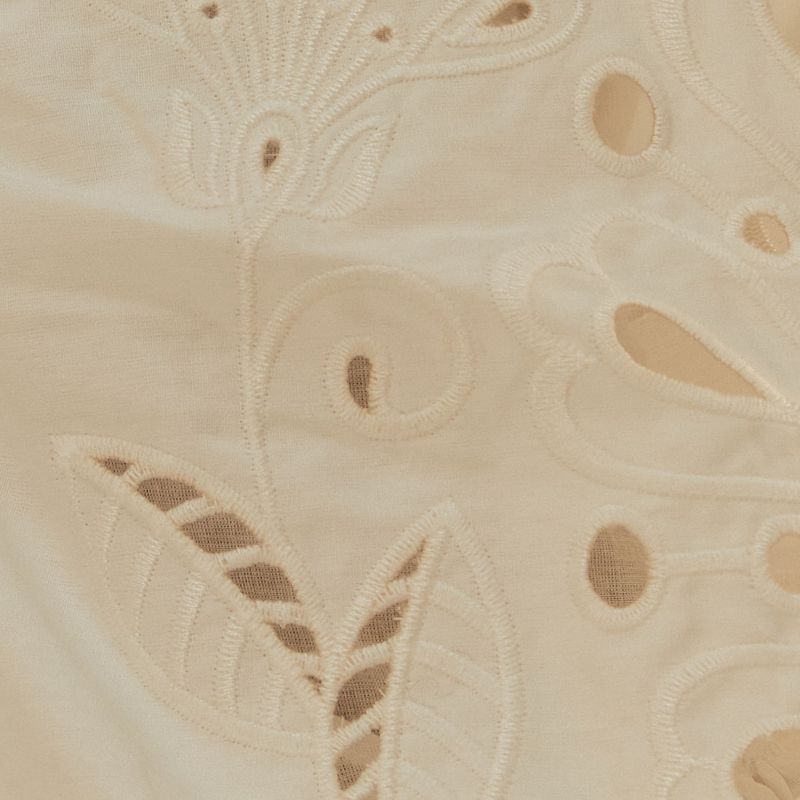 Close-up-del-bordado-richelieu-en-la-tela-del-vestido-destacando-el-trabajo-artesanal.