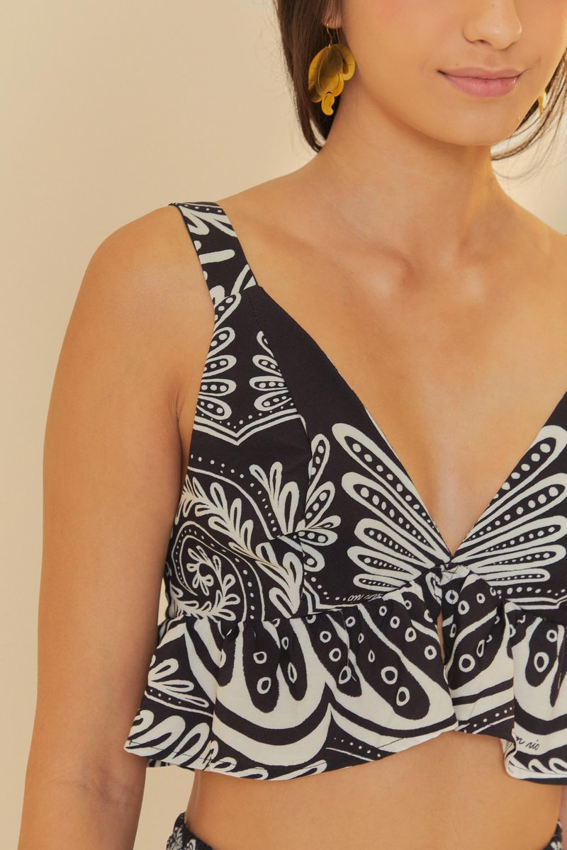 Detalle del escote en V del top estampado blanco y negro.