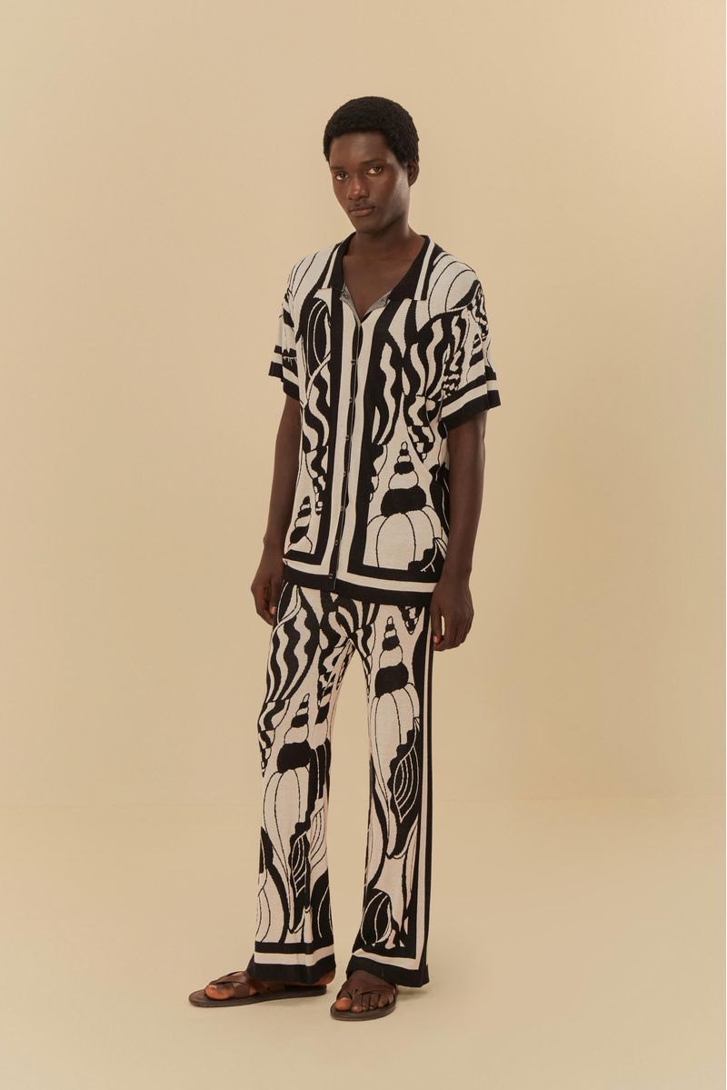 Modelo usando un conjunto de pantalón jacquard con estampado de conchas marinas, sobre fondo beige