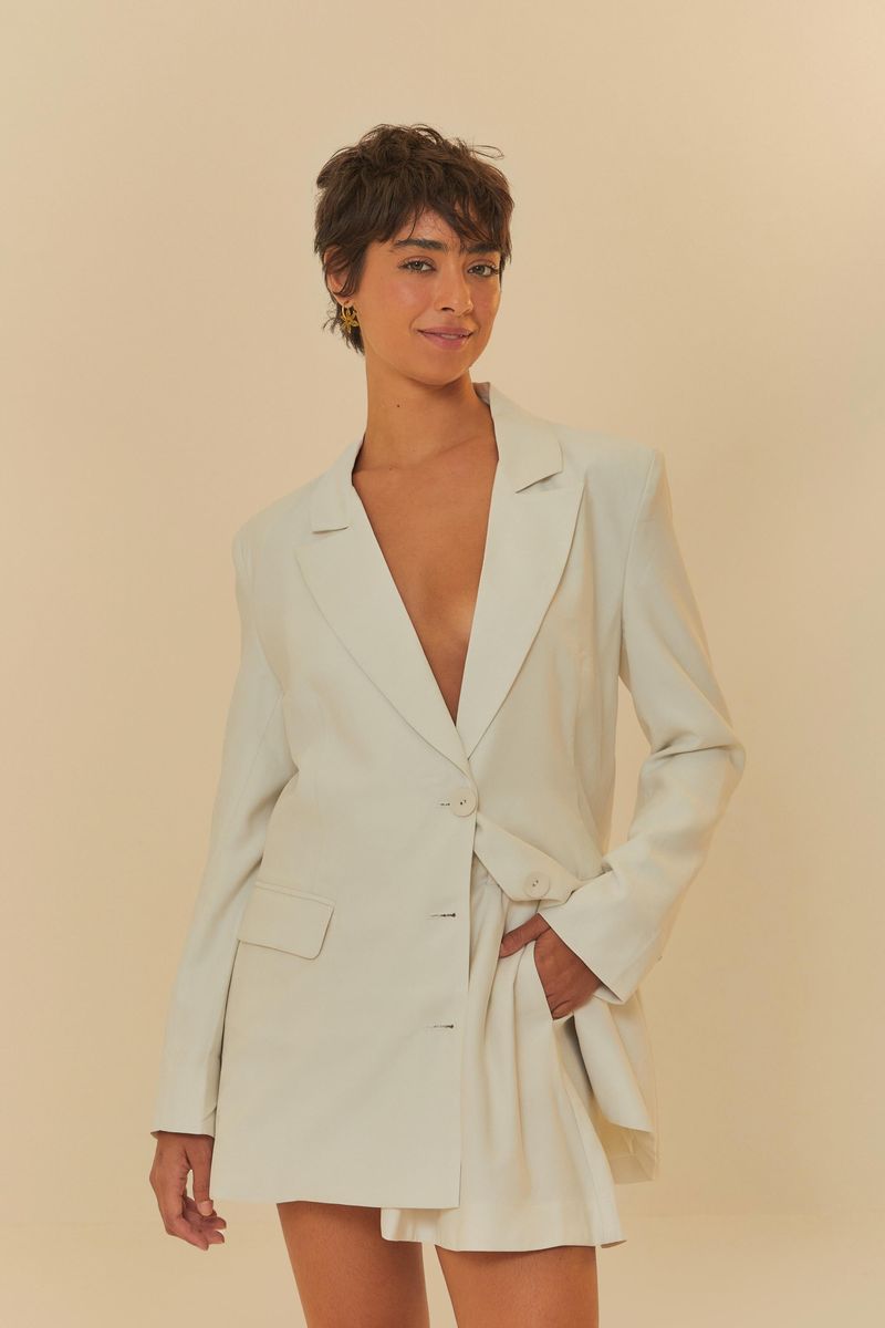 Modelo usando blazer y shorts de sastrería beige con pliegues.