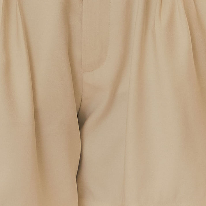 Detalle del tejido del short de sastrería beige, mostrando la textura y calidad.