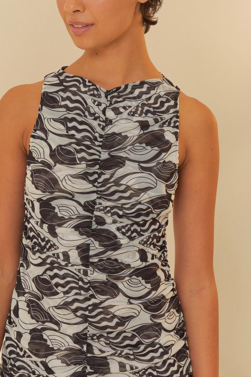 Detalle del tejido estampado del vestido corto con diseño de conchas y olas en blanco y negro.