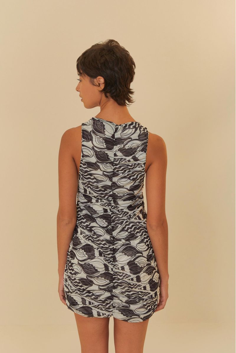 Vista lateral del vestido corto estampado con diseño de conchas y olas en blanco y negro.