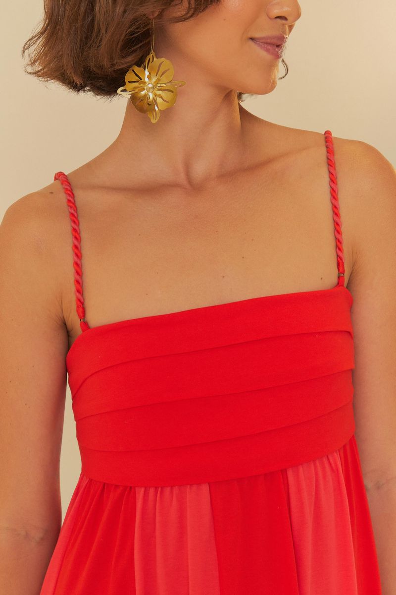 Vista trasera del vestido corto rojo, mostrando detalles de los tirantes y la caída.