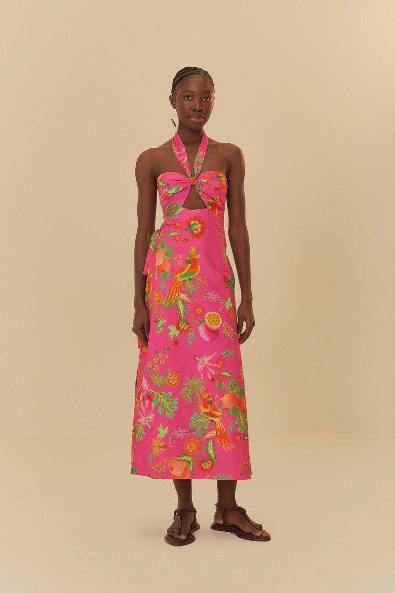 Vista frontal del vestido estampado con fondo rosa y detalles tropicales, destacando el escote halter y el ajuste en la cintura.