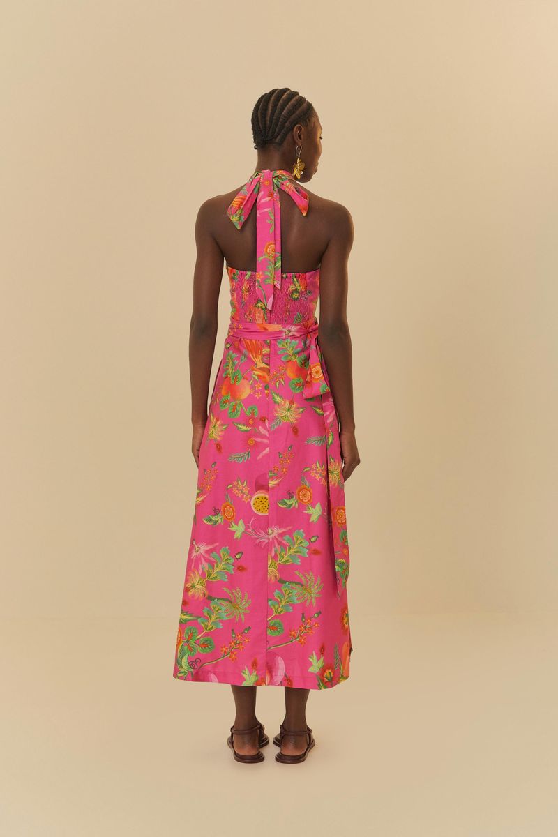 Detalle del corset del vestido estampado con fondo rosa y elementos tropicales, destacando el nudo central y el escote halter.