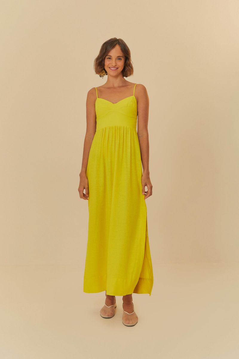 Vestido largo amarillo con tirantes finos, visto de frente en un ángulo diferente.
