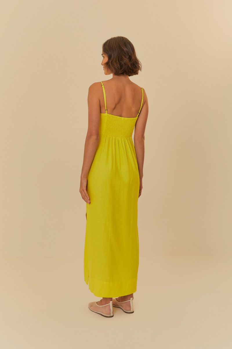 Vista trasera del vestido largo amarillo con detalle de cortes en el busto.
