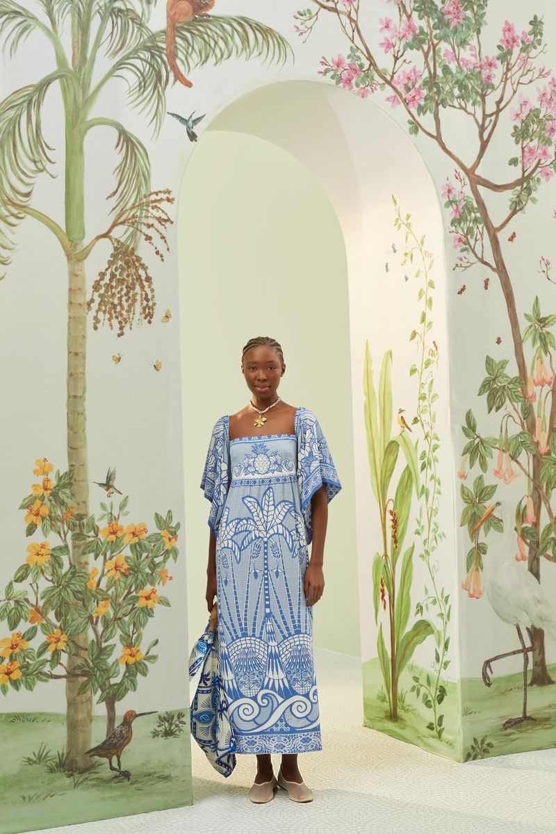 Vestido estampado azul con detalles florales y geométricos, exhibido en un ambiente decorado con plantas.