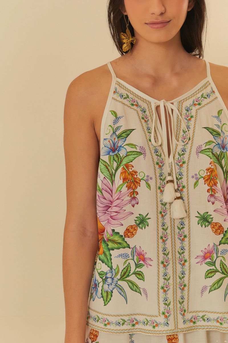 Detalle del estampado tropical con flores y frutas en la camiseta sin mangas.