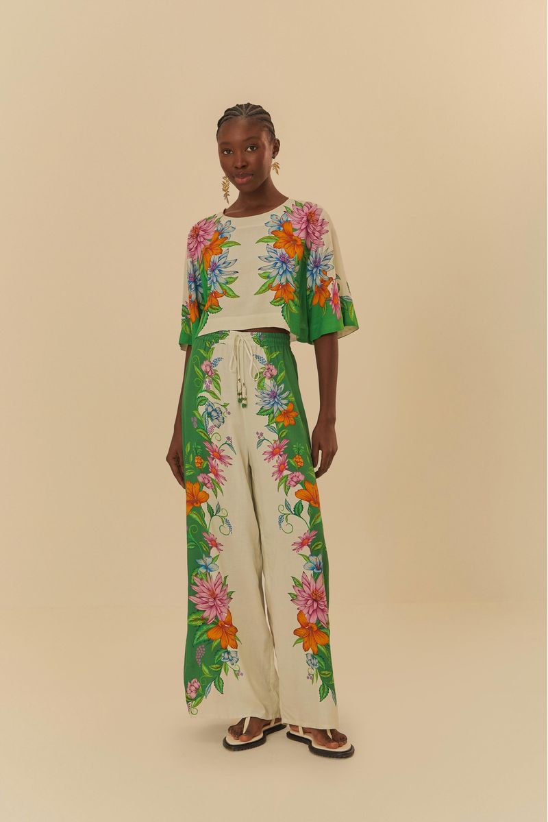 Modelo-vistiendo-pantalones-de-pata-de-elefante-con-estampado-floral-vibrante-combinado-con-blusa-de-mangas-largas-sobre-fondo-neutro