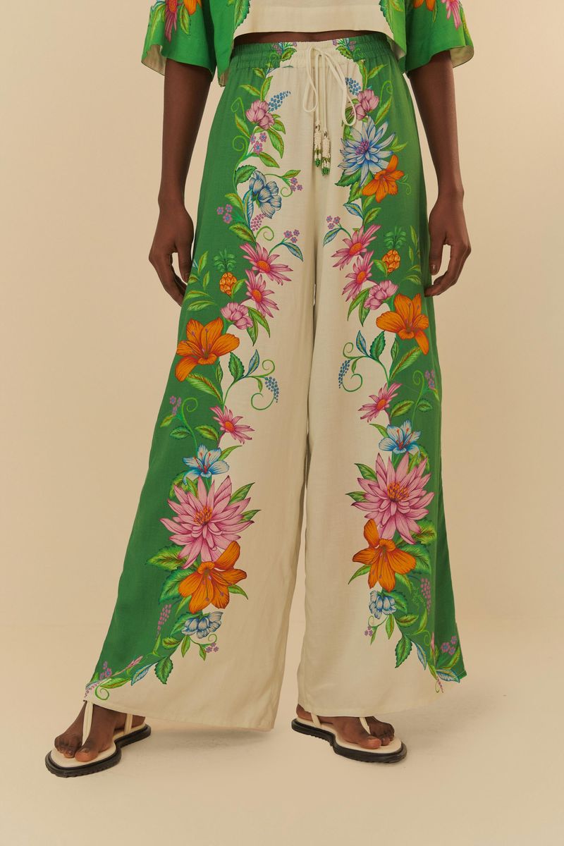 Primer-plano-del-pantalon-de-pata-de-elefante-destacando-el-estampado-floral-colorido-sobre-fondo-verde-y-blanco
