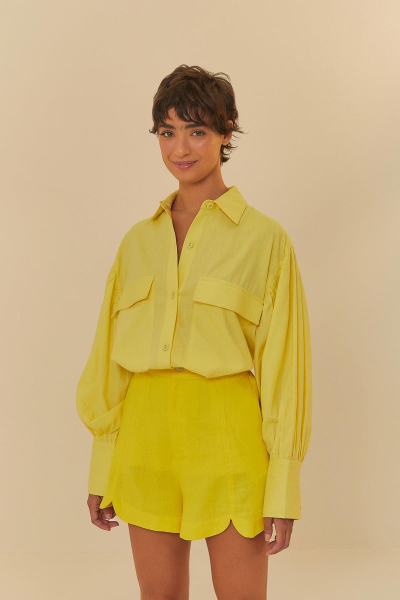 Imagen de una modelo llevando un conjunto amarillo con camisa de mangas largas y short con cortes al frente, vista frontal.