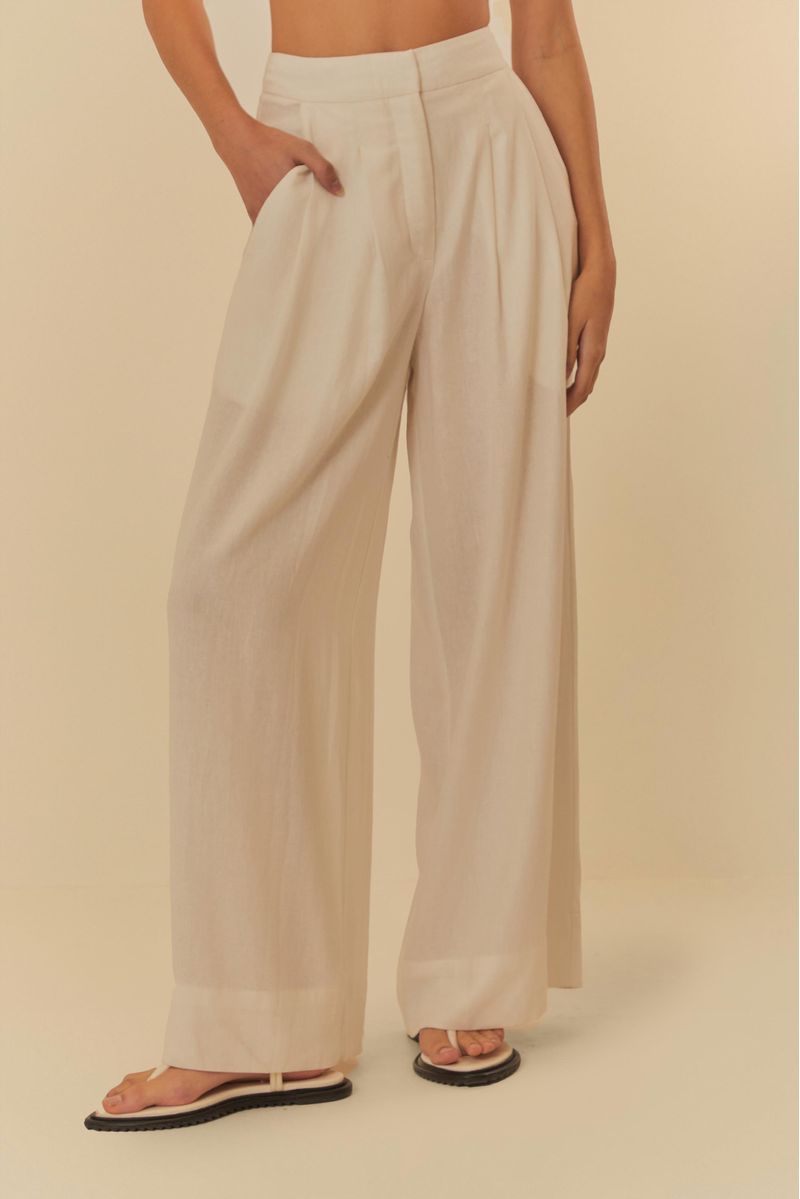 Detalle-frontal-del-pantalon-beige-con-pliegues-y-bolsillos-destacando-el-diseño-de-sastreria.