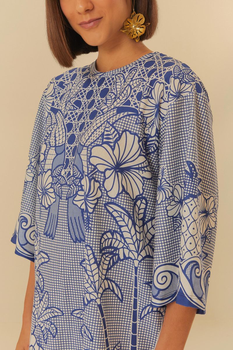 Imagen-mostrando-un-primer-plano-del-vestido-estilo-camiseta-con-estampado-azul-y-blanco-destacando-los-detalles-florales-y-geometricos.