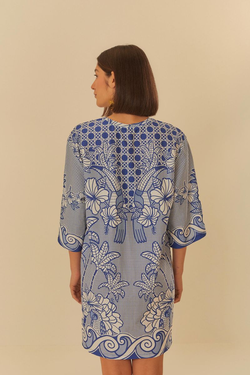 Imagen-mostrando-el-vestido-estilo-camiseta-con-estampado-azul-y-blanco-visto-desde-atras-con-detalles-florales-y-geometricos.