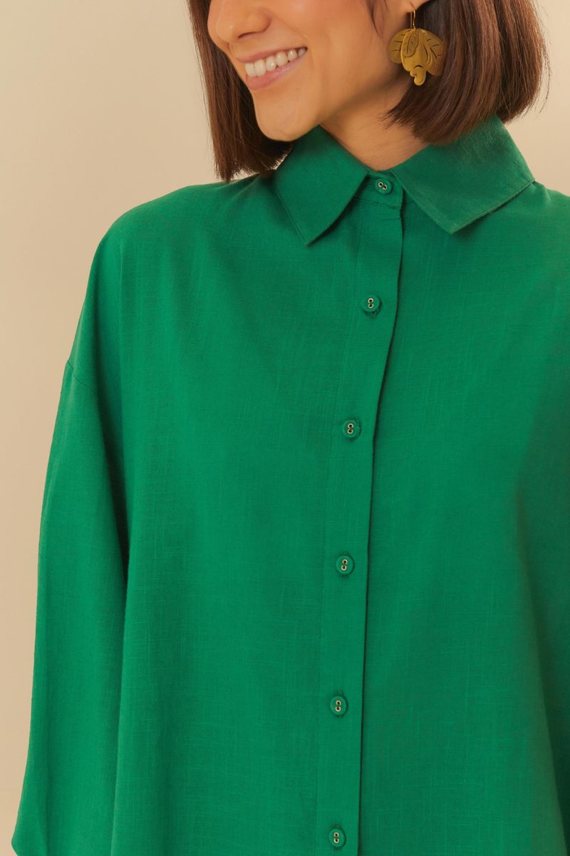 Detalle del cuello y cierre con botones de la camisa larga verde.