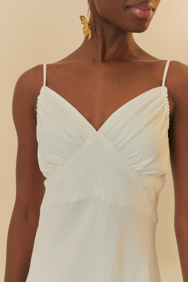 Vestido largo blanco con tirantes finos y escote cruzado, visto de espaldas.