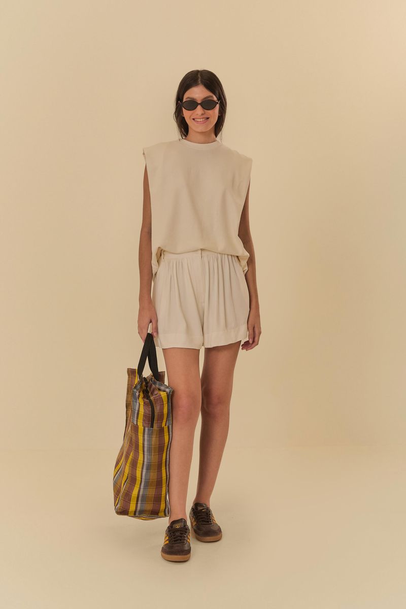 Modelo-usando-un-short-fruncido-beige-con-bolsillo-combinado-con-una-blusa-sin-mangas.