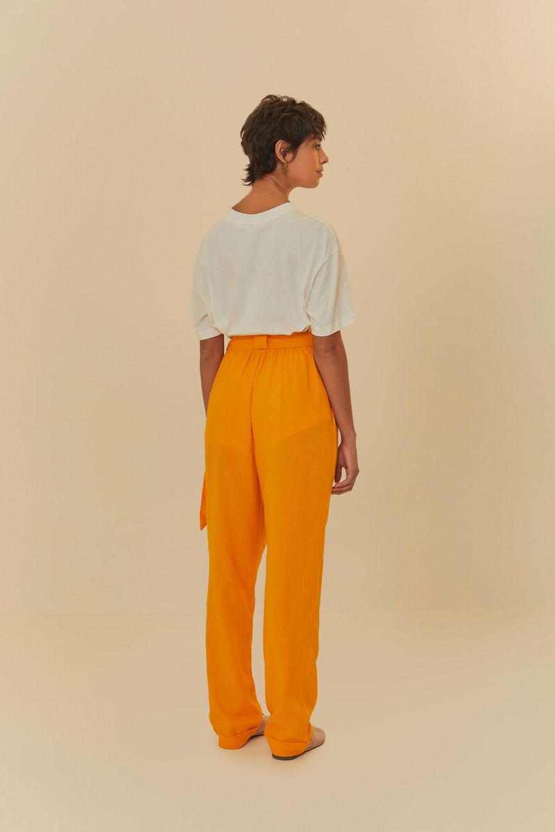 Vista trasera del pantalón recto naranja, destacando el ajuste y el caimiento de la tela ligera