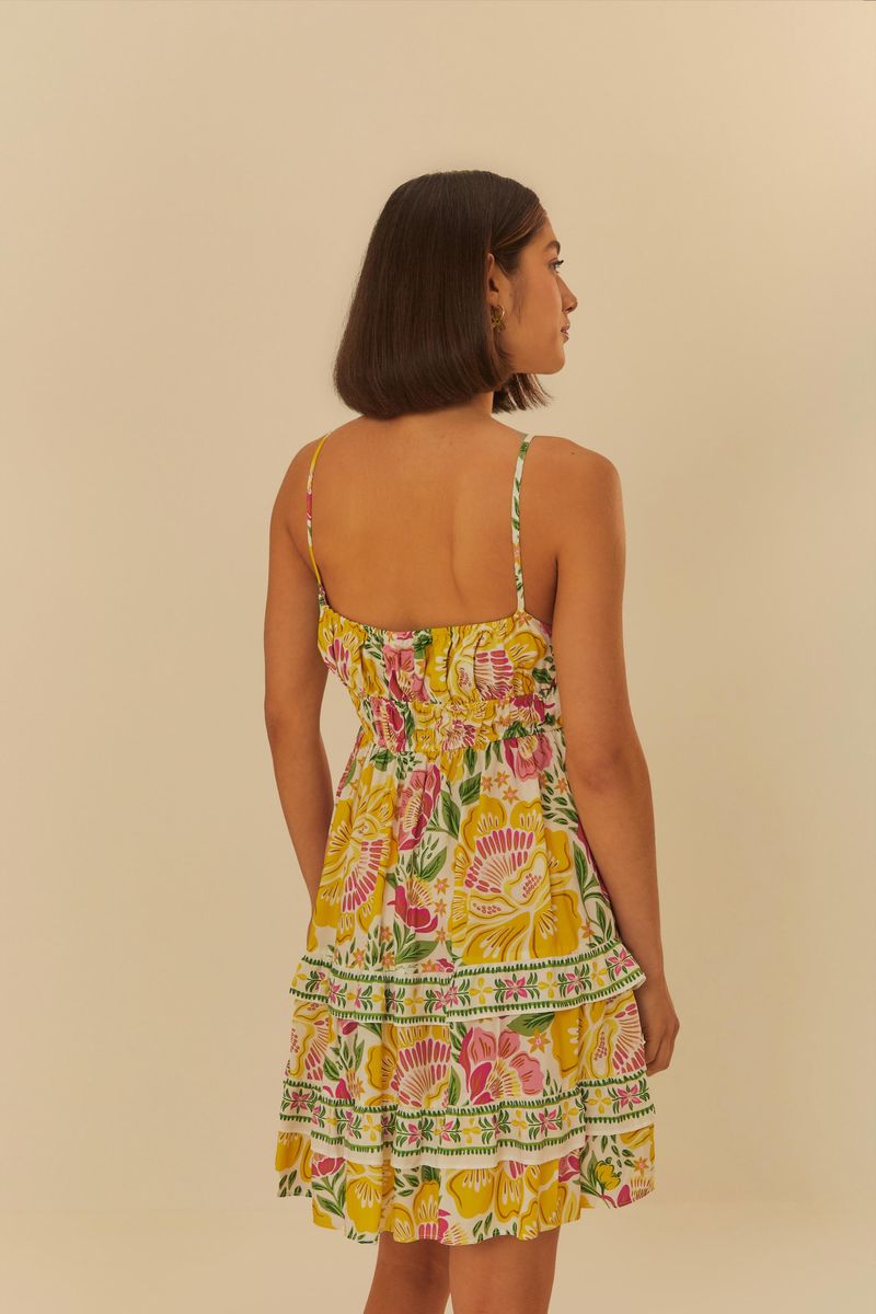 Vista trasera del vestido corto floral destacando los tirantes ajustables y el diseño de la espalda.