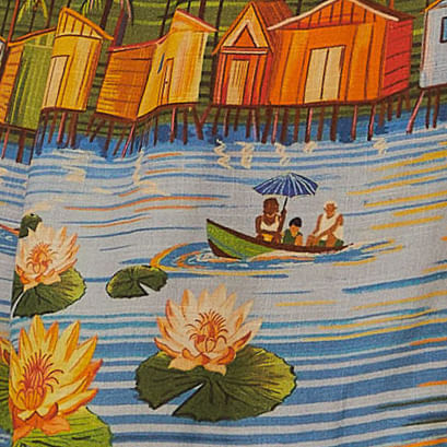 Primer-plano-del-estampado-de-paisaje-ribereño-en-el-vestido-corto-mostrando-detalles-de-casas-y-vegetacion.