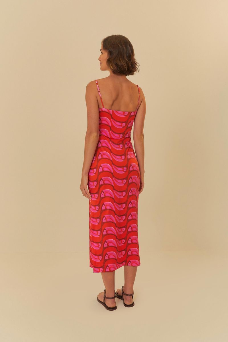 Imagen de un vestido midi con estampado vibrante en tonos de rojo y rosa, visto desde el lado.