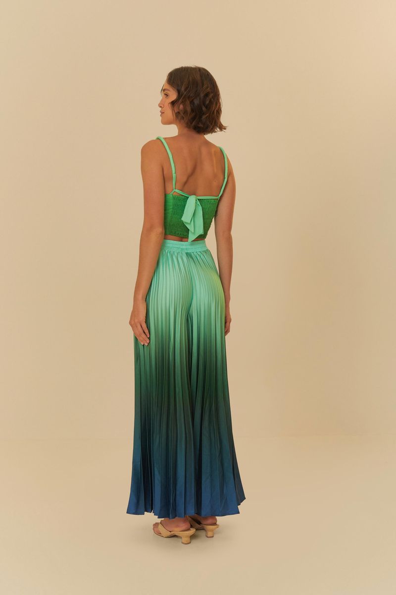 Vista trasera del conjunto con top verde y pantalón largo plisado con efecto degradado en tonos de azul y verde.