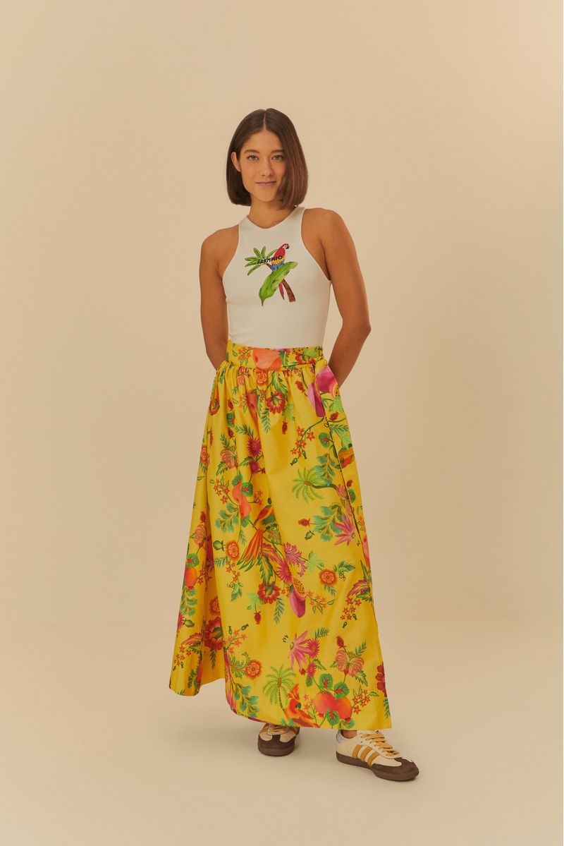 Modelo usando falda larga estampada con diseños tropicales y frutales, vista frontal completa.