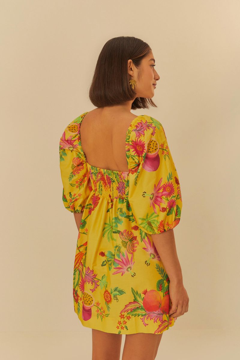 Vista posterior del vestido corto estampado, mostrando el detalle del escote en la espalda y el patrón floral.