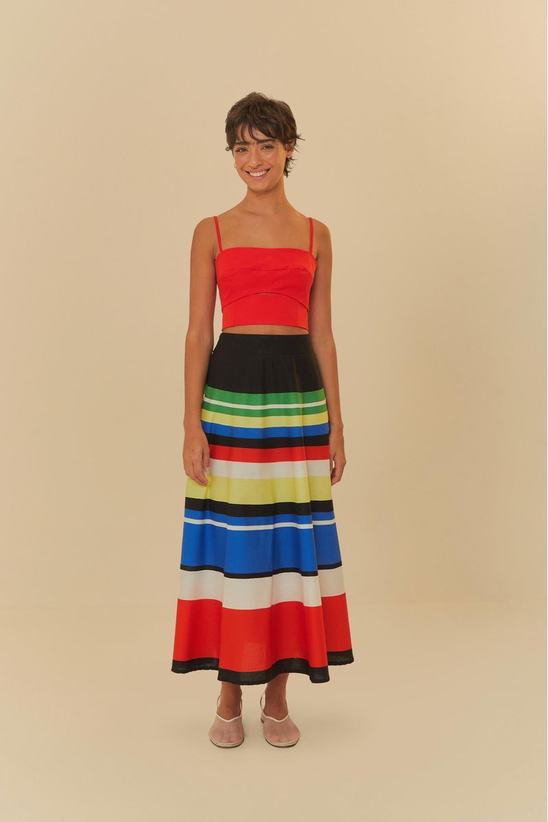 Blusa cortada roja con recortes, vista completa con falda a rayas.