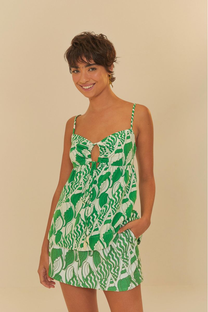 Modelo-usando-una-falda-corta-estampada-con-conchas-del-mar-en-tonos-verdes-y-blancos-combinada-con-un-top-correspondiente.