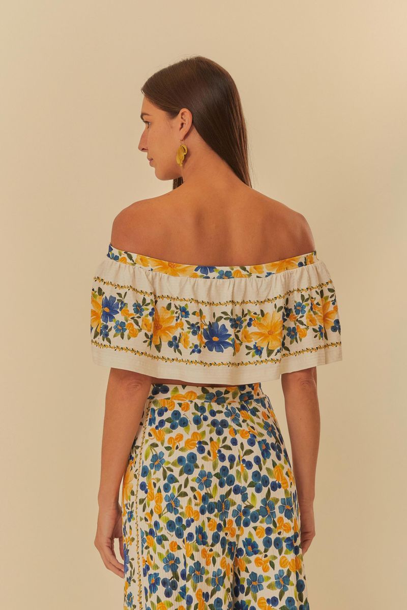 Vista posterior de la blusa floral con volantes, mostrando el diseño y la caída.