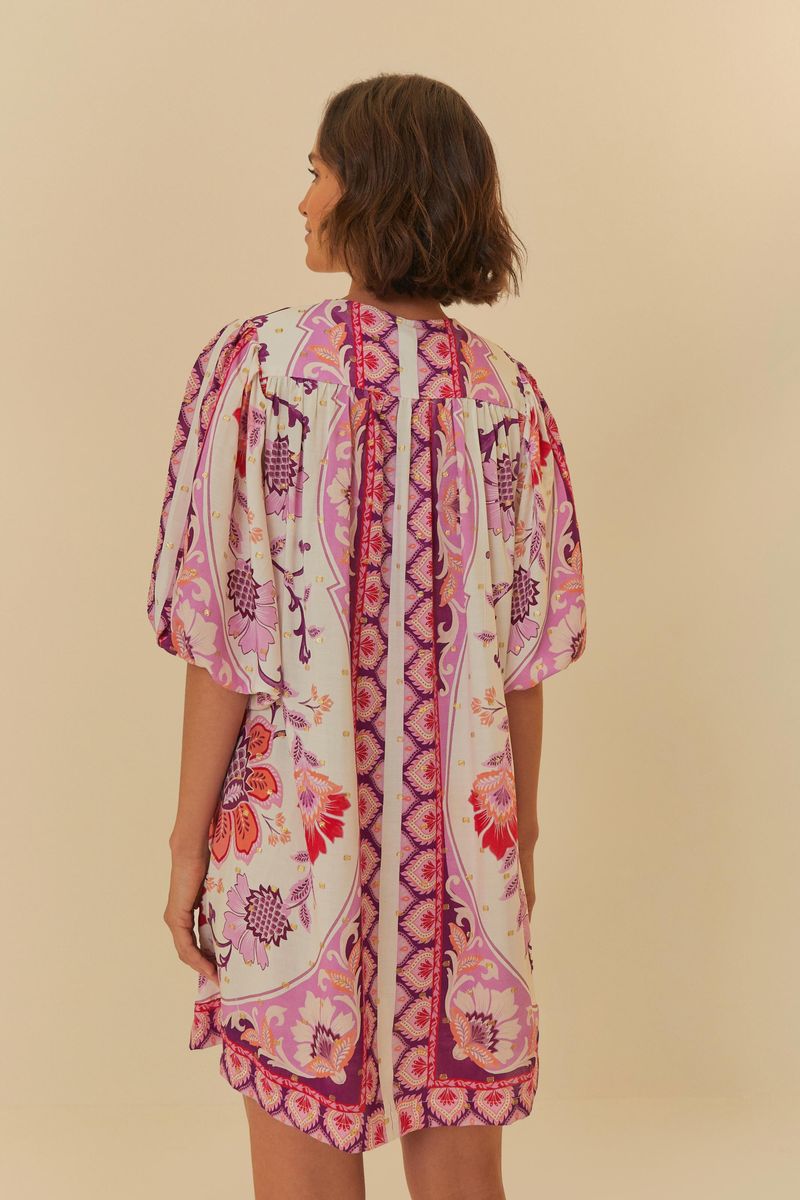 Vista trasera del vestido corto estampado con patrón floral y mangas abullonadas.