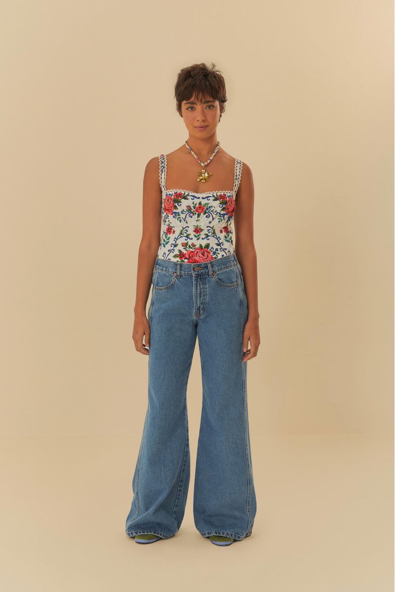 Modelo usando pantalón jeans con recorte y pretina elástica, vista trasera.