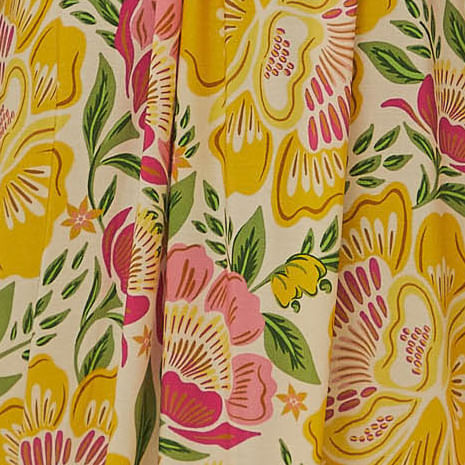 Detalle-del-estampado-floral-vibrante-del-vestido-mostrando-flores-amarillas-y-rosadas-con-hojas-verdes.
