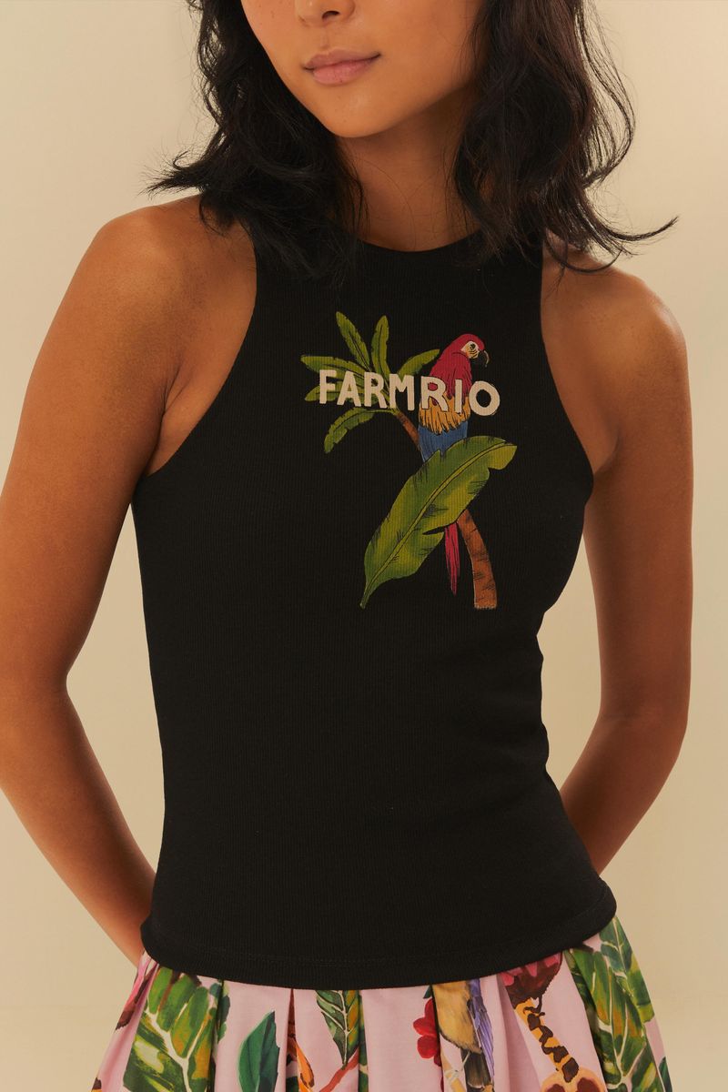 Acercamiento al estampado de tucano y follaje en la camiseta negra.