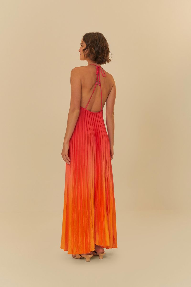 Vestido largo plisado con efecto degradado en tonos rojo y naranja, visto desde la espalda.