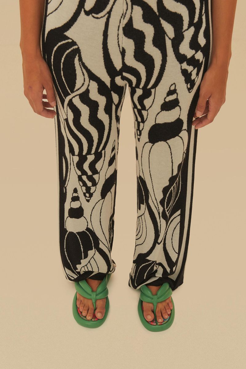 Imagen de una sandalia verde con estampado tropical en la plantilla, vista de perfil.